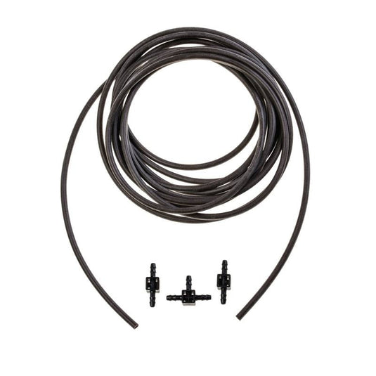 Coiled Blumat drip tubing beside two couplings and a tee
