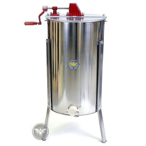 Two-frame manual stainless steel honey extractor with hand crank, angled view.