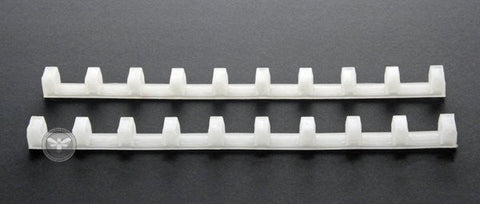 Plastic frame spacing tool positioning nine frames evenly in a super.