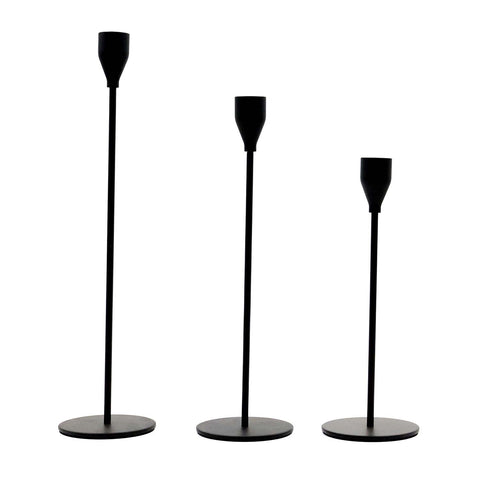 Set of three matte black taper candle holders arranged for a tablescape display.