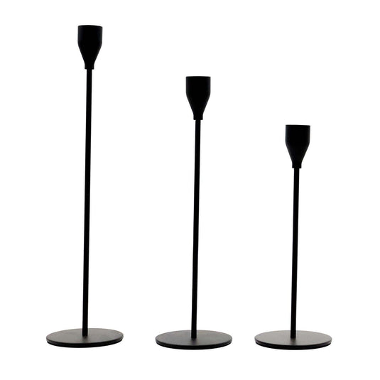 Set of three matte black taper candle holders arranged for a tablescape display.